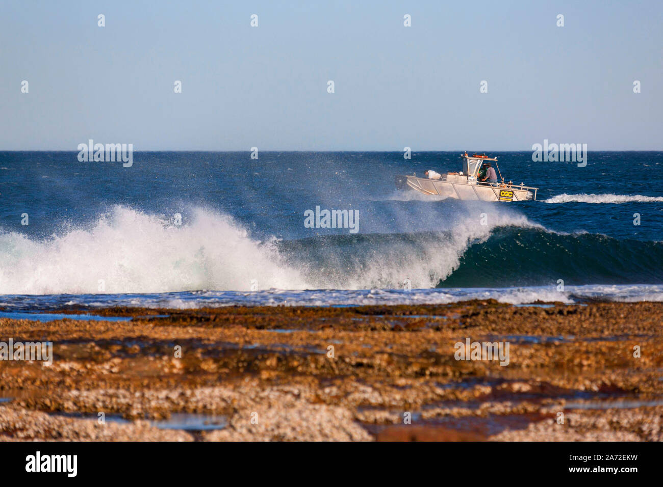 Petit bateau à l'extérieur de corail avec les vagues déferlantes, l'ouest de l'Australie Kalbarri Banque D'Images