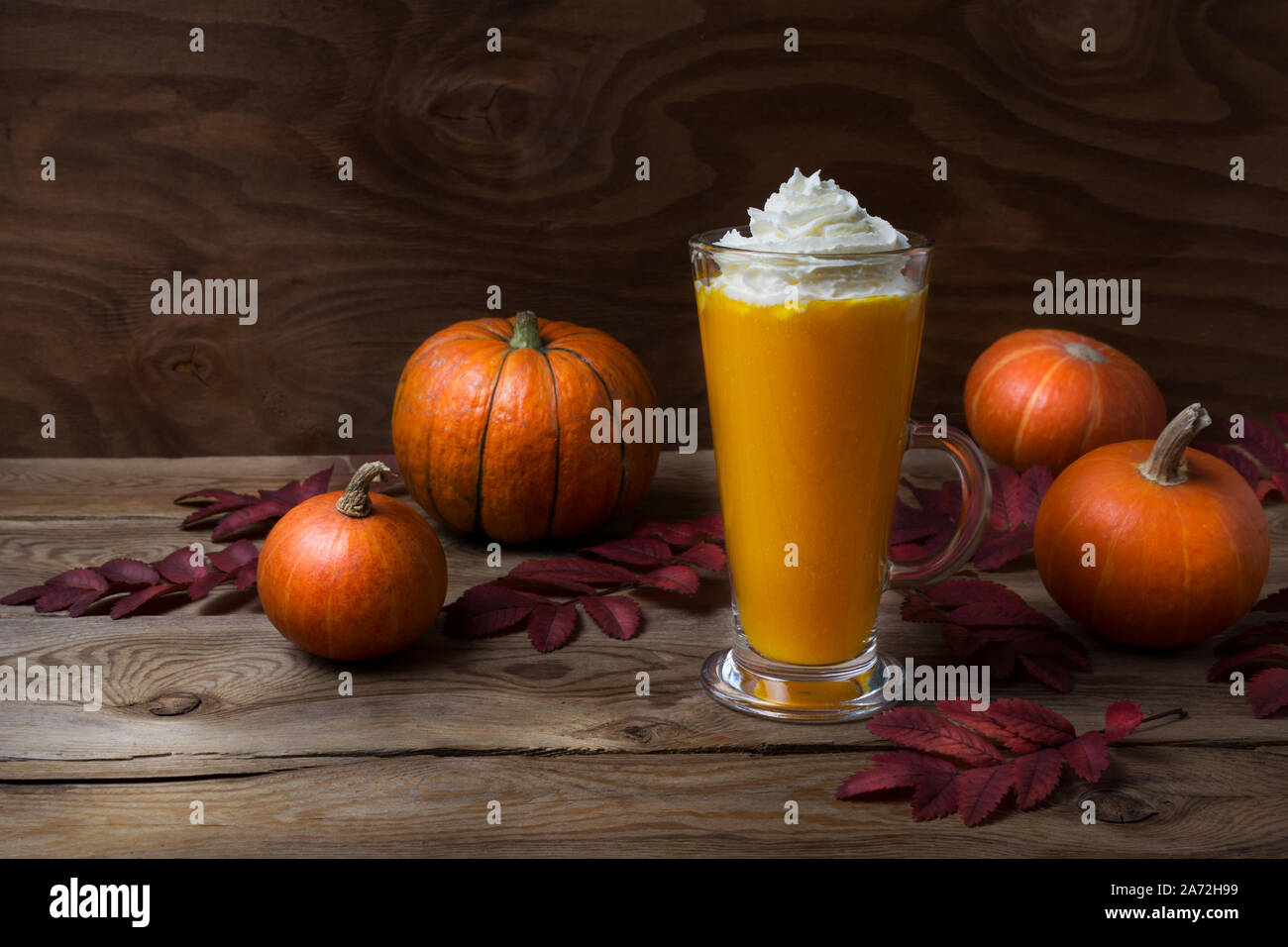 Maison d'automne potiron vegan latte d'épices avec de la crème chantilly sur la table en bois rustique Banque D'Images