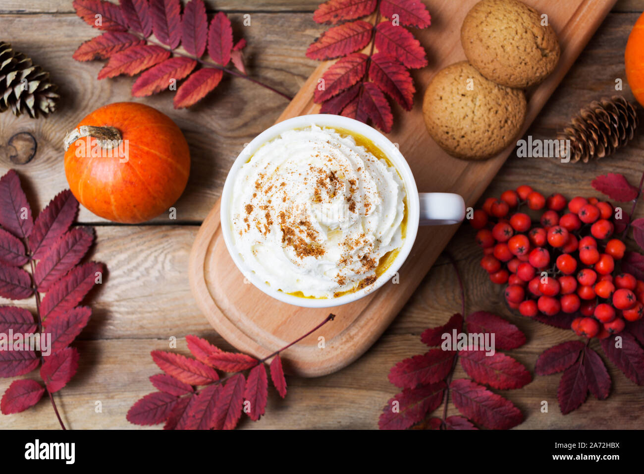 Pumpkin spice latte café tasse de crème fouettée, de biscuits, de feuilles d'automne et Rowan berries, vue du dessus Banque D'Images