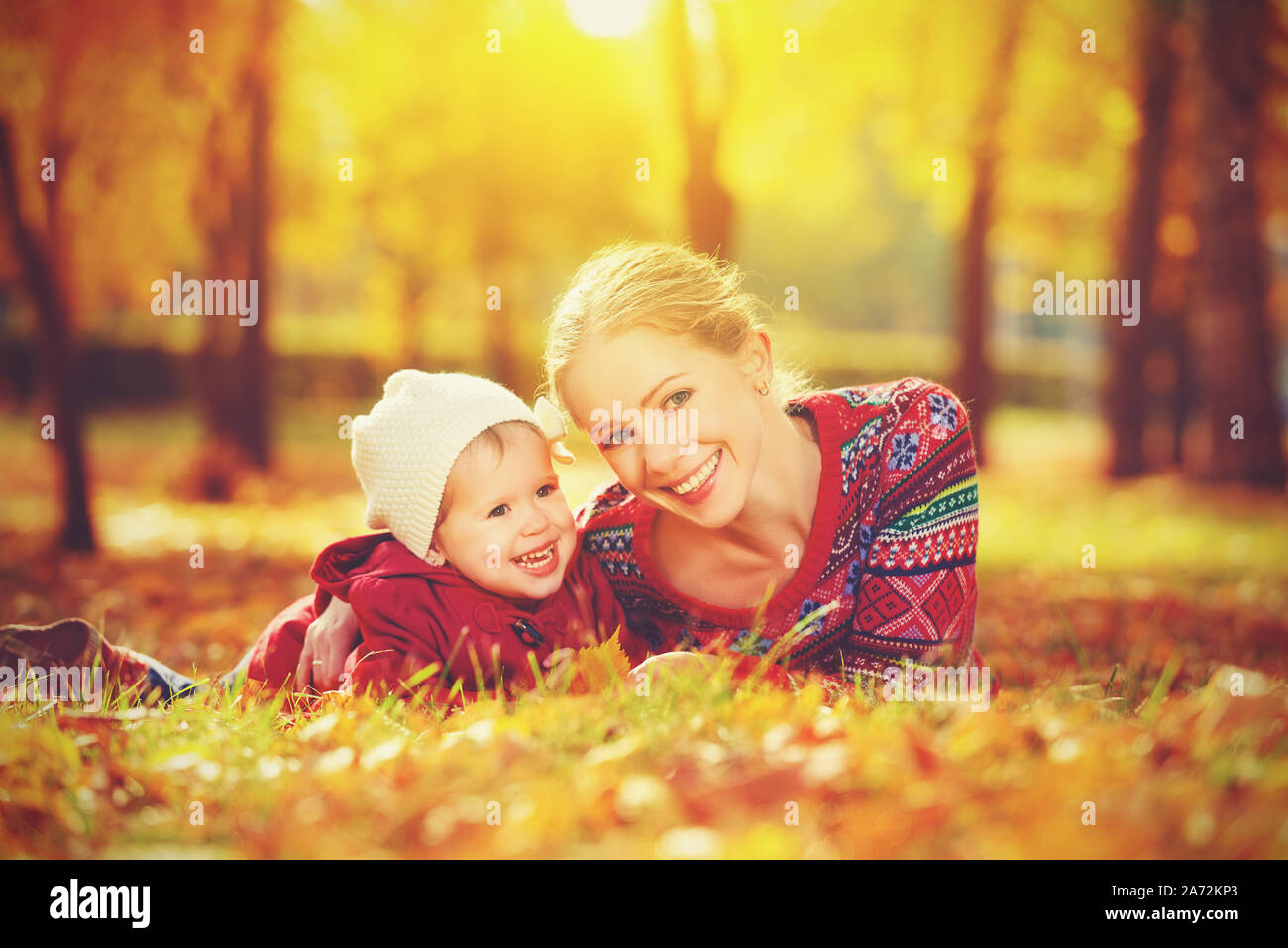 Famille heureuse : Mère et enfant fille jouer et rire dans l'automne sur la nature dans la nature Banque D'Images