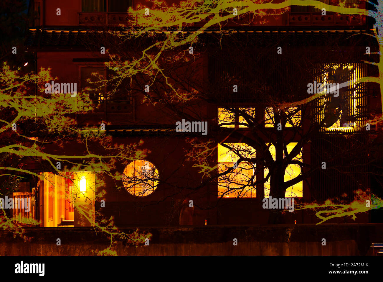 Fond mystérieux avec de grands arbres et de la vieille maison sombre décoré de lumière orange. Arrière-plan de l'Halloween. Banque D'Images