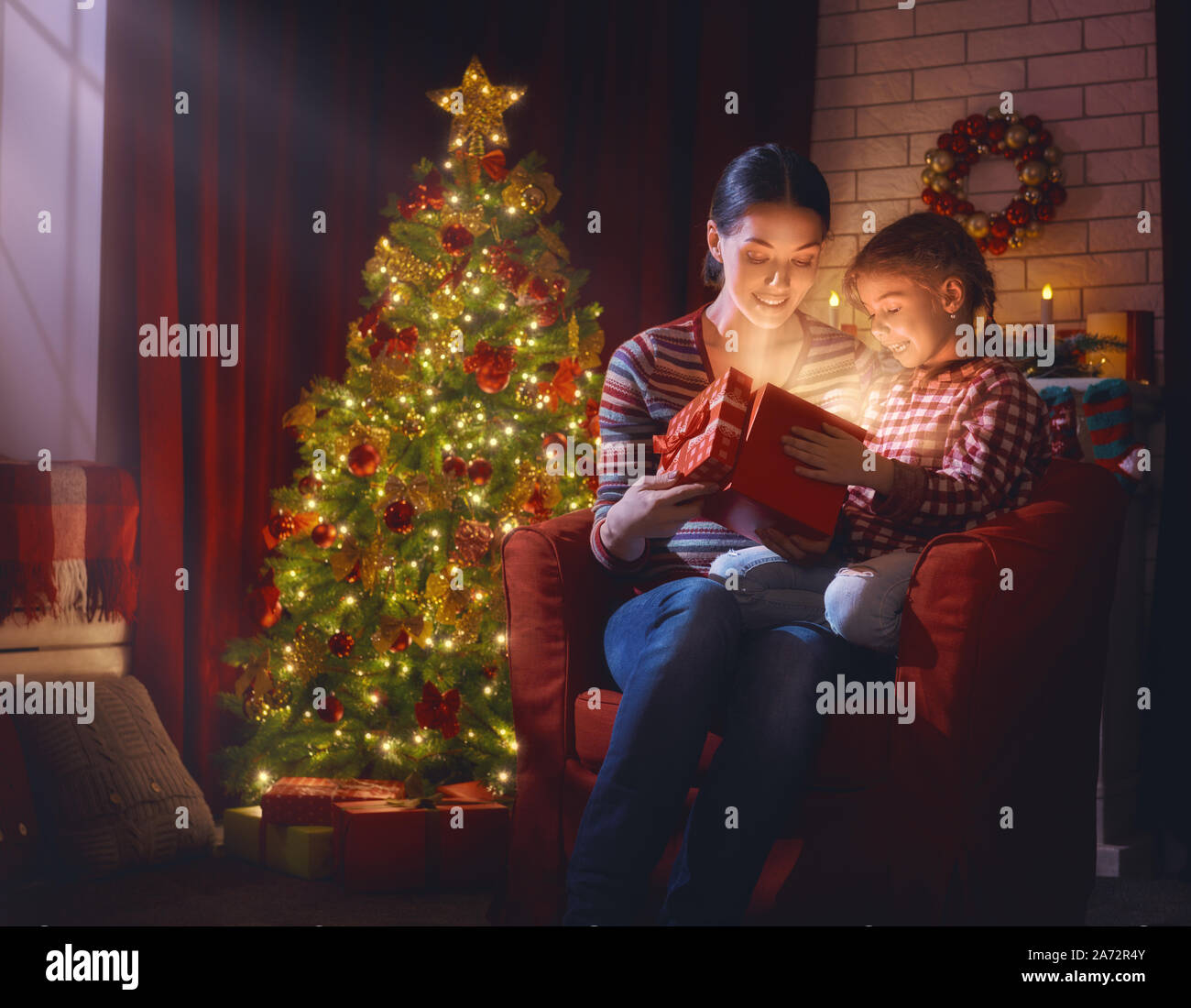 Joyeux Noël et de bonnes vacances ! La mère et l'enfant fille avec magic boîte-cadeau de Noël. Les traditions familiales de Noël. Banque D'Images