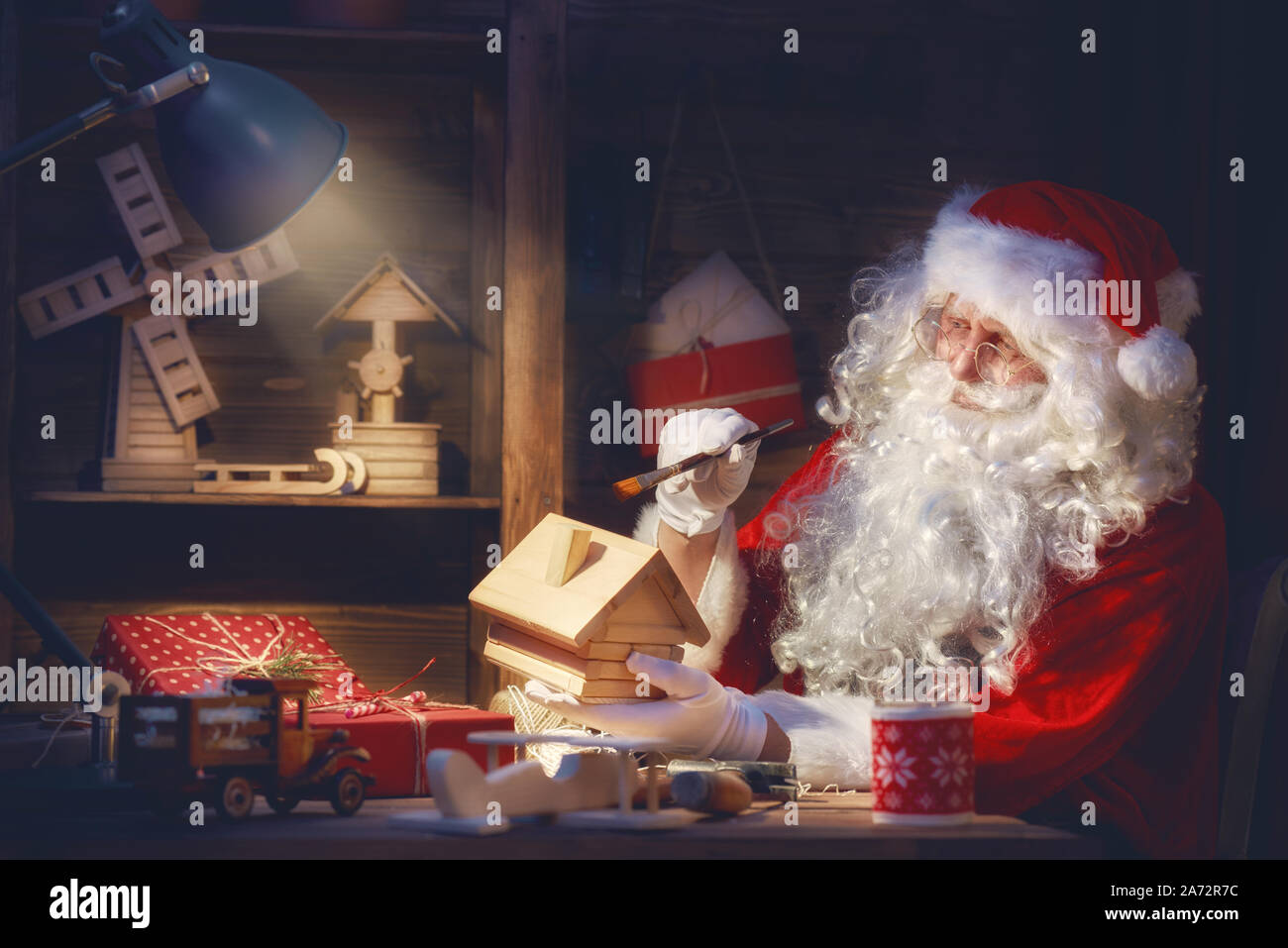 Joyeux Noël et de bonnes vacances ! Le Père Noël est en train de préparer des cadeaux pour les enfants pour Noël à son bureau à la maison. Légendes et traditions de Noël. Banque D'Images