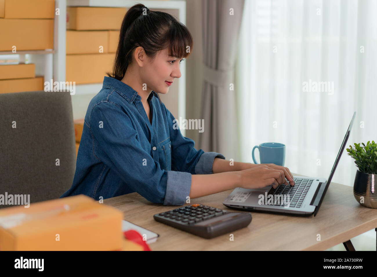 Charmante belle asiatique propriétaire adolescent femme d'affaires travailler à la maison pour faire des achats en ligne, à l'ordre dans un ordinateur portable avec l'équipement de bureau, entreprene Banque D'Images