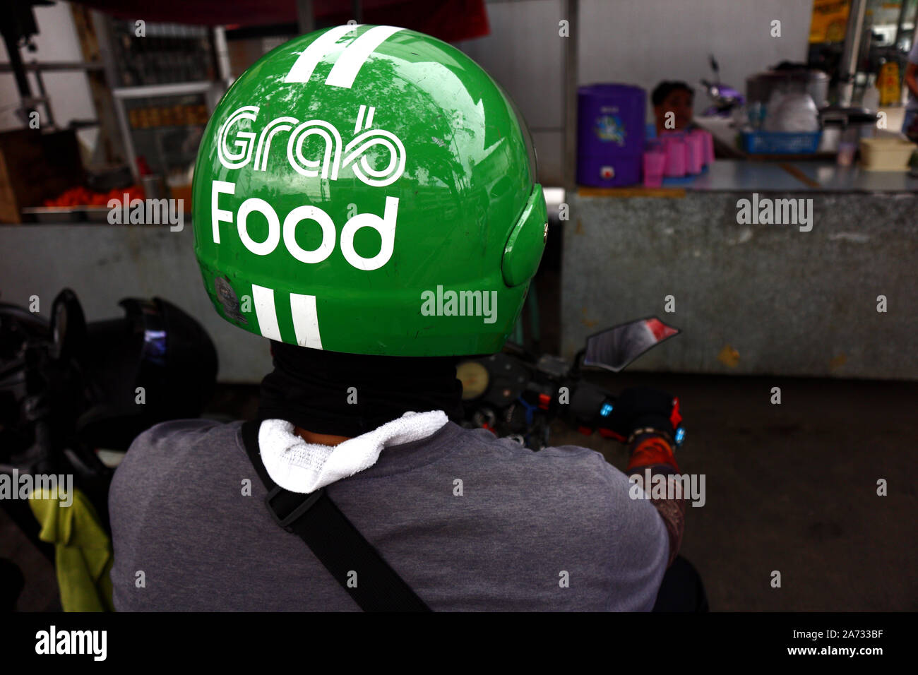 ANTIPOLO CITY, PHILIPPINES - 28 octobre 2019 : conducteur de moto populaire pilote de livraison de nourriture est par le trottoir sur sa moto et attendre Banque D'Images
