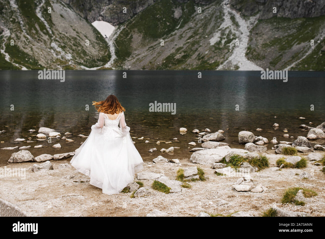 Jolie jeune femme passer du temps dans les montagnes près du lac. La mariée se présente. Banque D'Images
