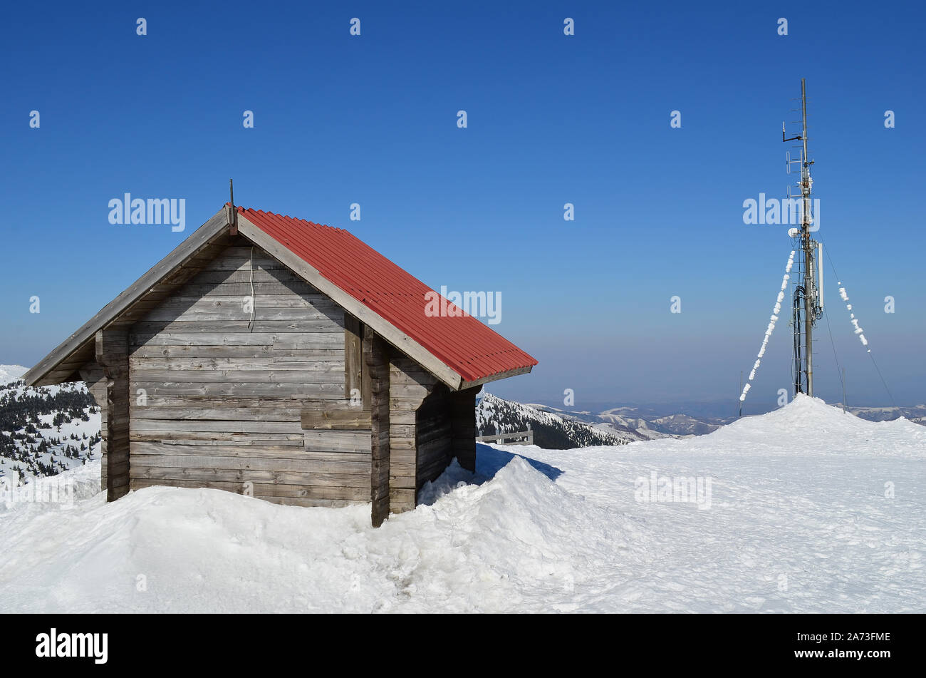 La fin de l'hiver, un abri en bois et de l'antenne sur le dessus de la mountin, journée ensoleillée et la neige fondante Banque D'Images