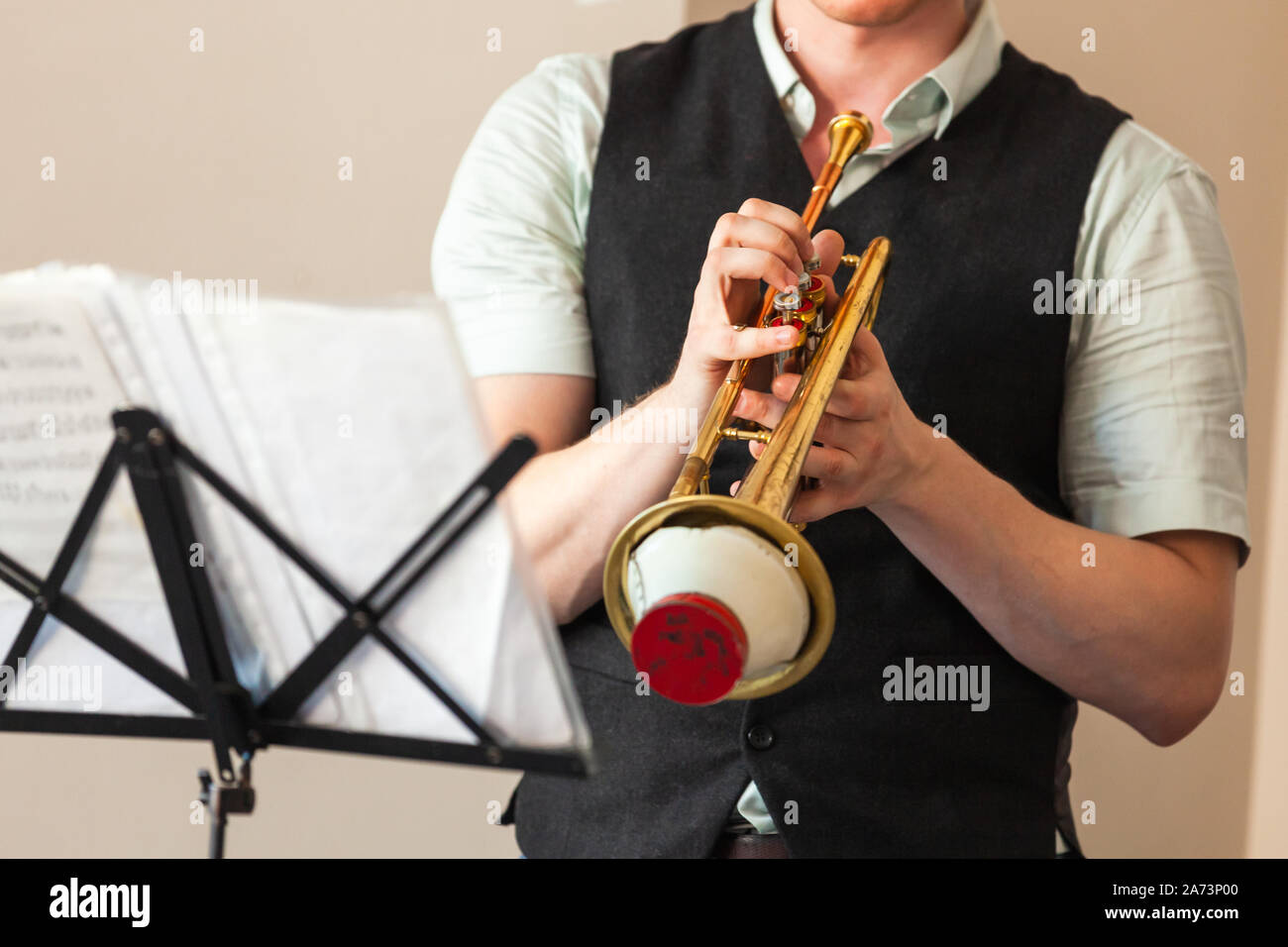 Arrière-plan de la musique live. La trompette avec sourdine tout droit dans le mains. La photo en gros plan avec selective focus Banque D'Images