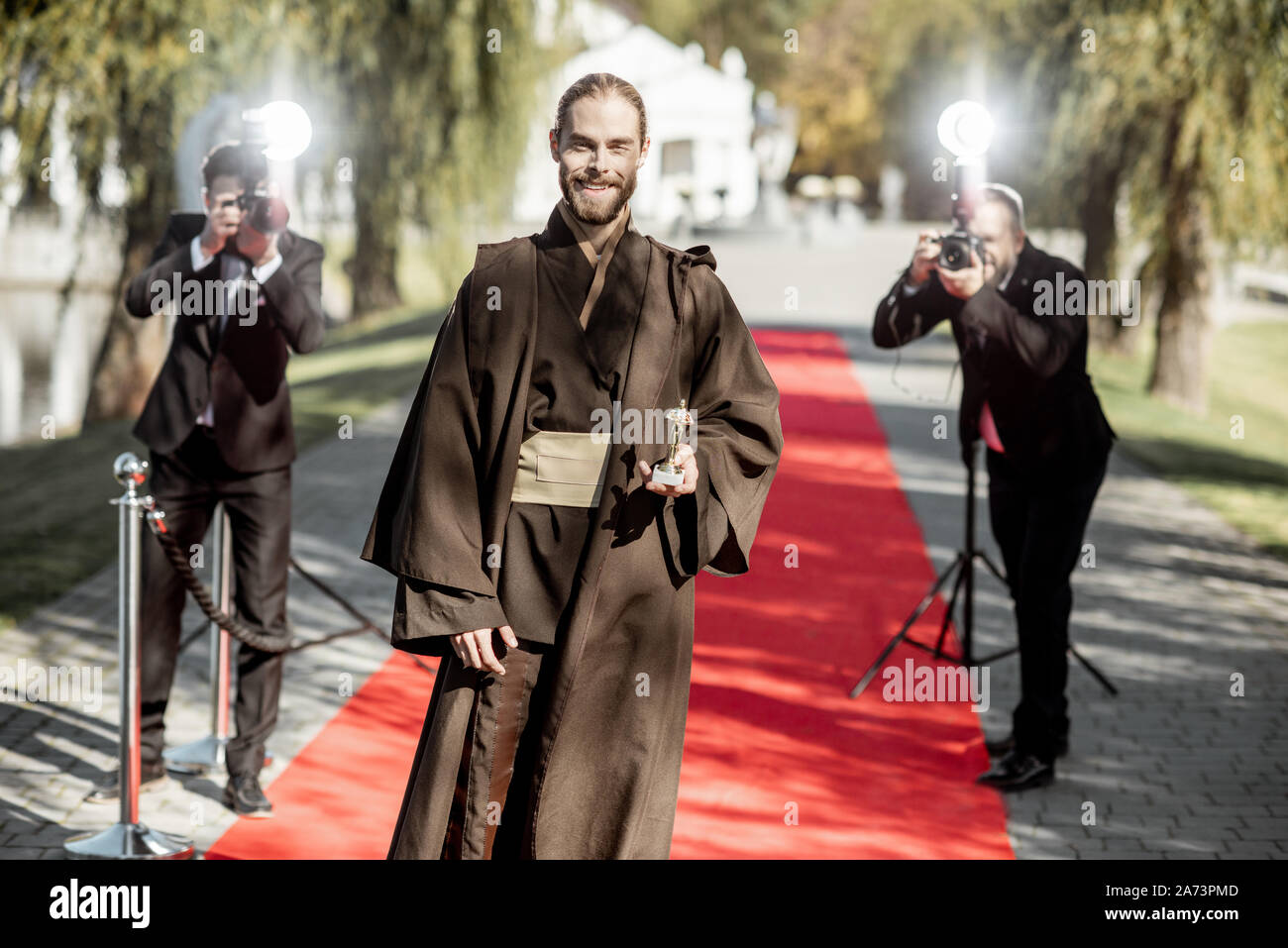 L'homme en costume comme un personnage de film bien connu à pied avec des reporters photo ennuyeux sur le tapis rouge lors de la cérémonie de remise des prix Banque D'Images