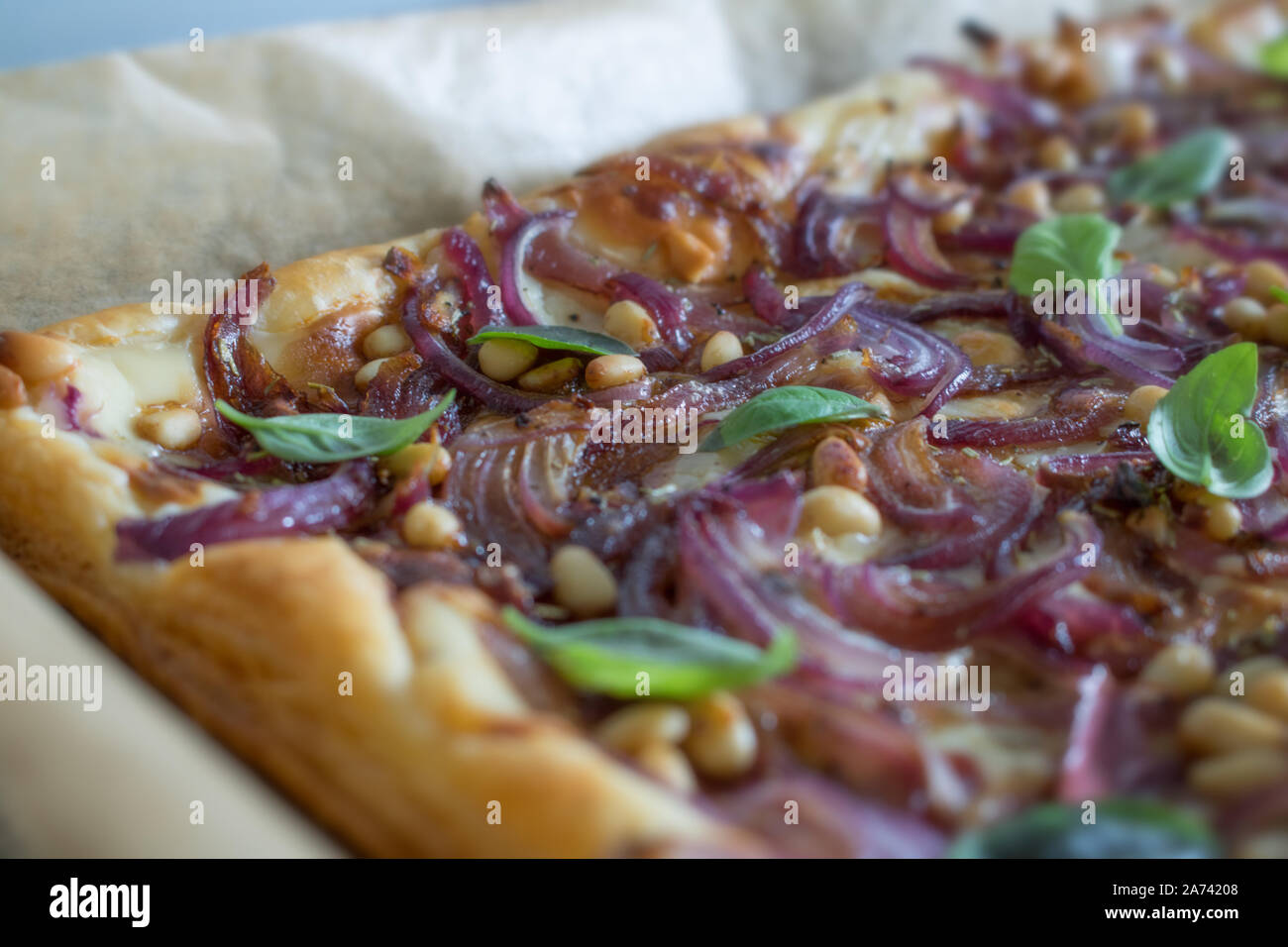 La photographie culinaire de pâte feuilletée aux oignons rouges, réduction de vinaigre balsamique et les pignons de pin Banque D'Images