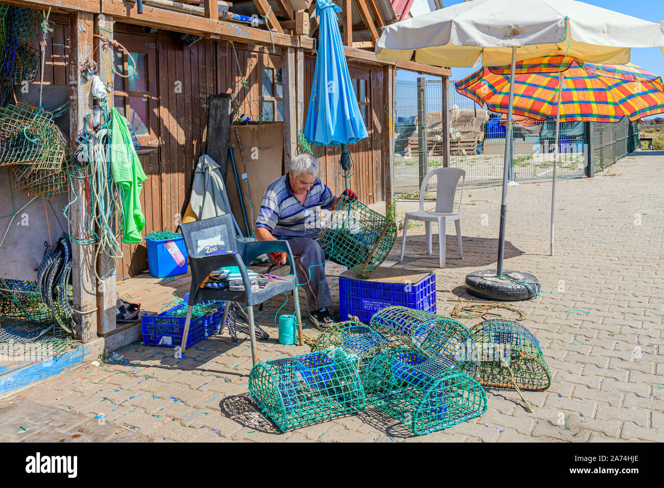 Pêcheur local réparant les filets de pieuvre de mending pièges pots piège pot net, Santa Luzia, est de l'Algarve, Portugal. Banque D'Images