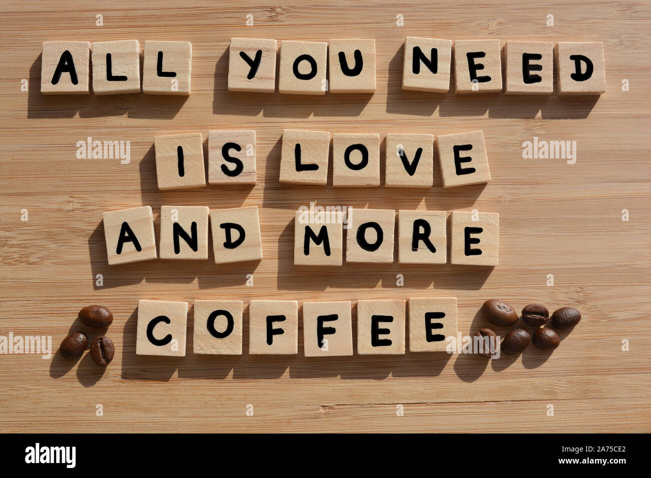 Tout ce qu'il vous faut, c'est l'amour et plus de café-. Mots en lettres de l'alphabet en bois 3d avec les grains de café sur un fond de bois de bambou Banque D'Images
