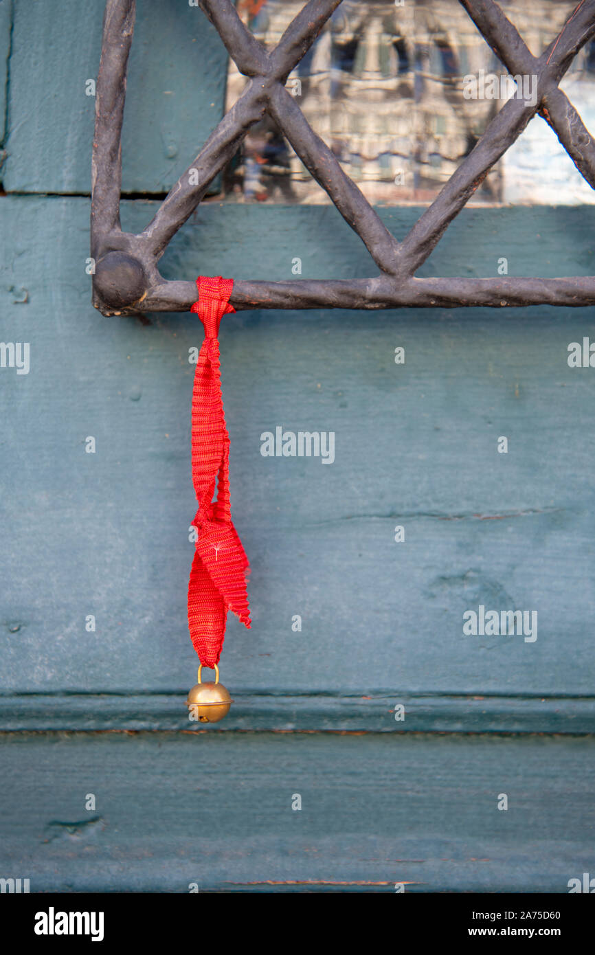Un ruban rouge avec un grelot attaché en tant que decortaion à une porte sur une maison en Alsace France Banque D'Images
