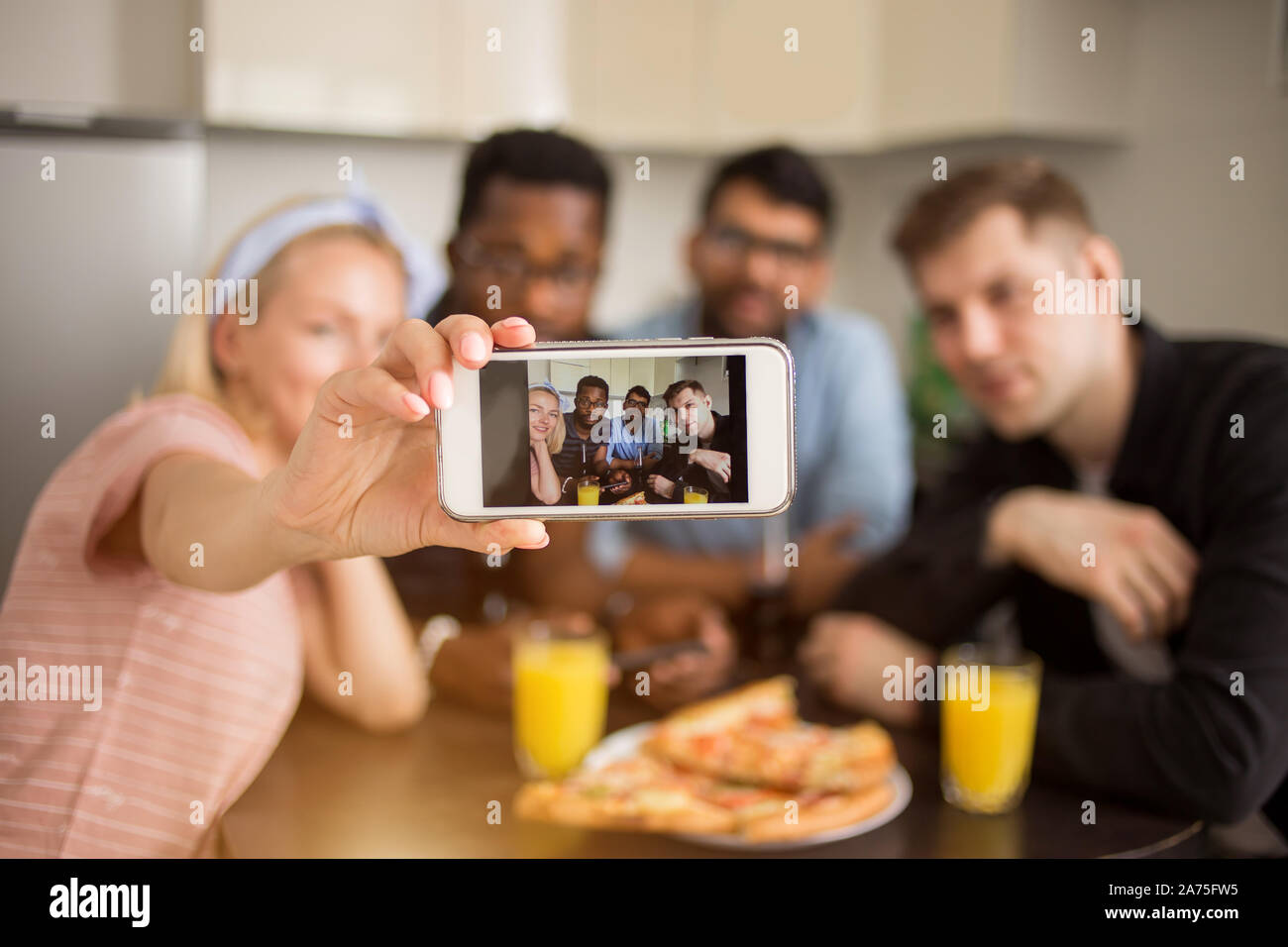Groupe multiracial d'amis prenant tout en selfies assis à table et en train de déjeuner. Amitié, loisirs et technologie concept. Les étudiants gais havi Banque D'Images