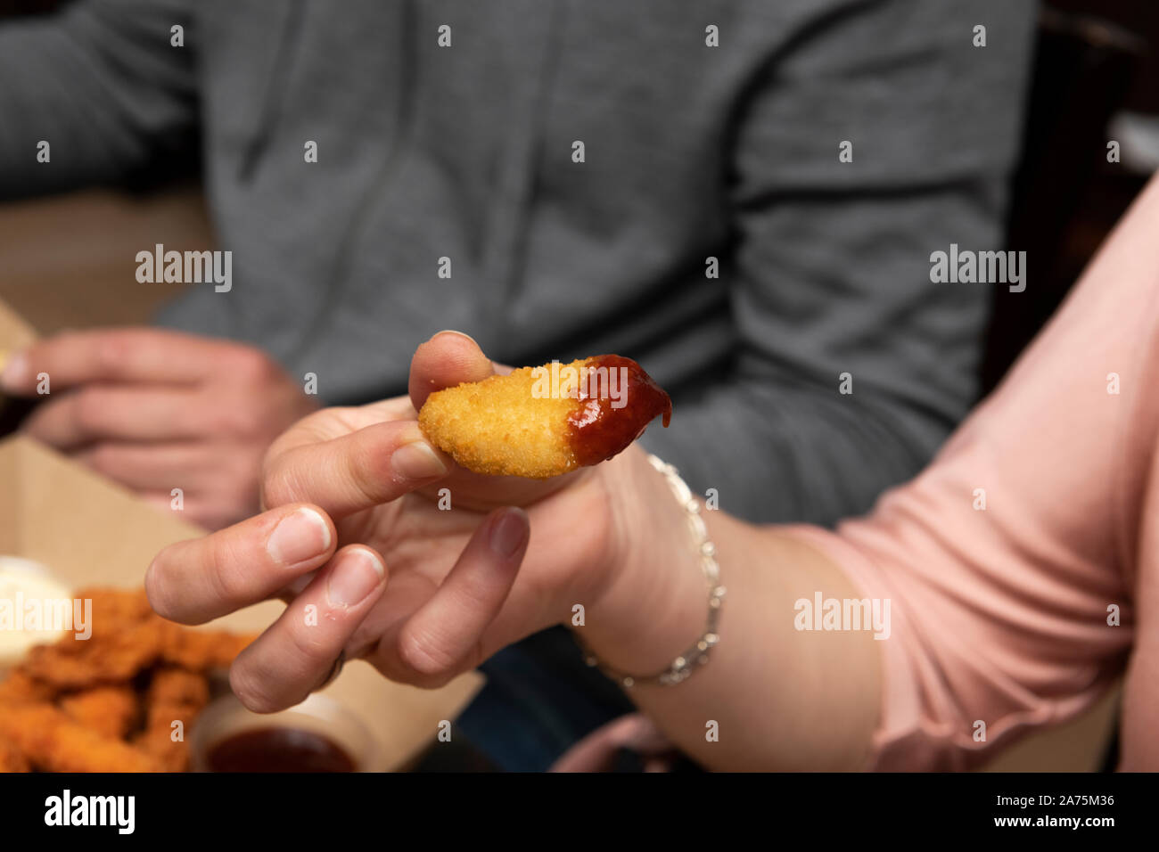 Woman eating chicken nuggets dans un restaurant Banque D'Images