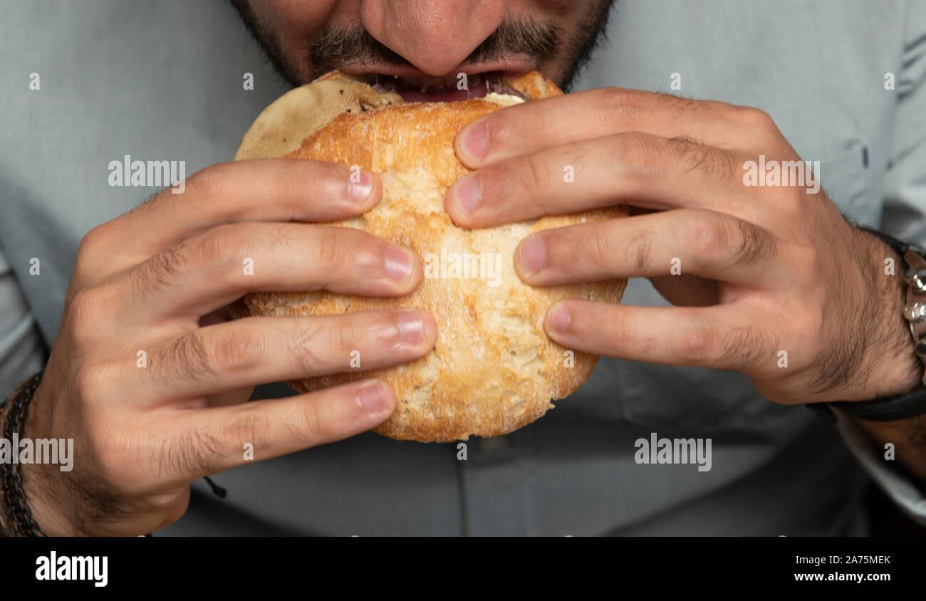 Man eating sandwich burger dans un restaurant Banque D'Images