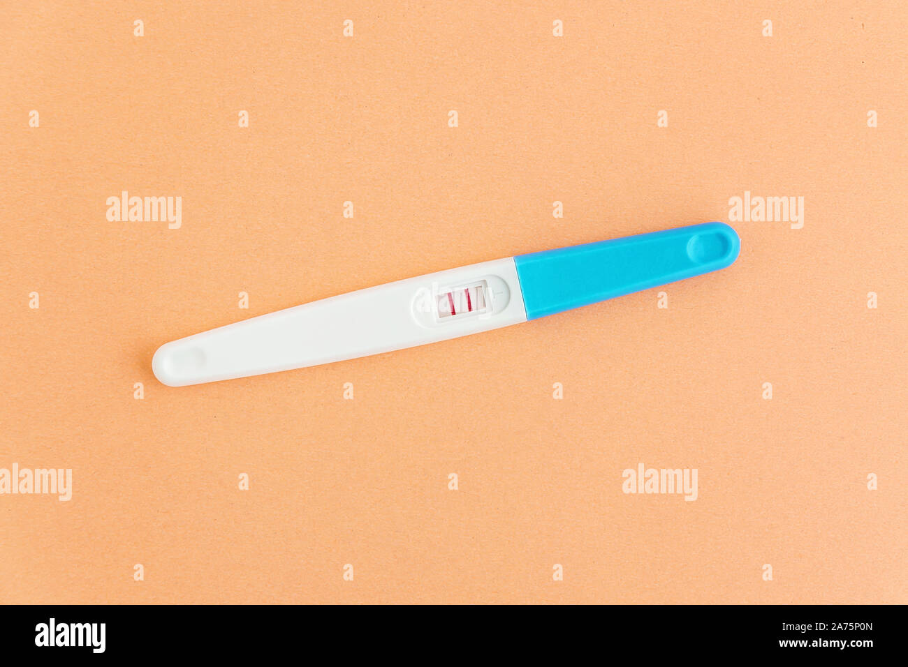 Test de grossesse positif sur fond orange. Planification de la grossesse, l'essai d'avoir bébé. Banque D'Images