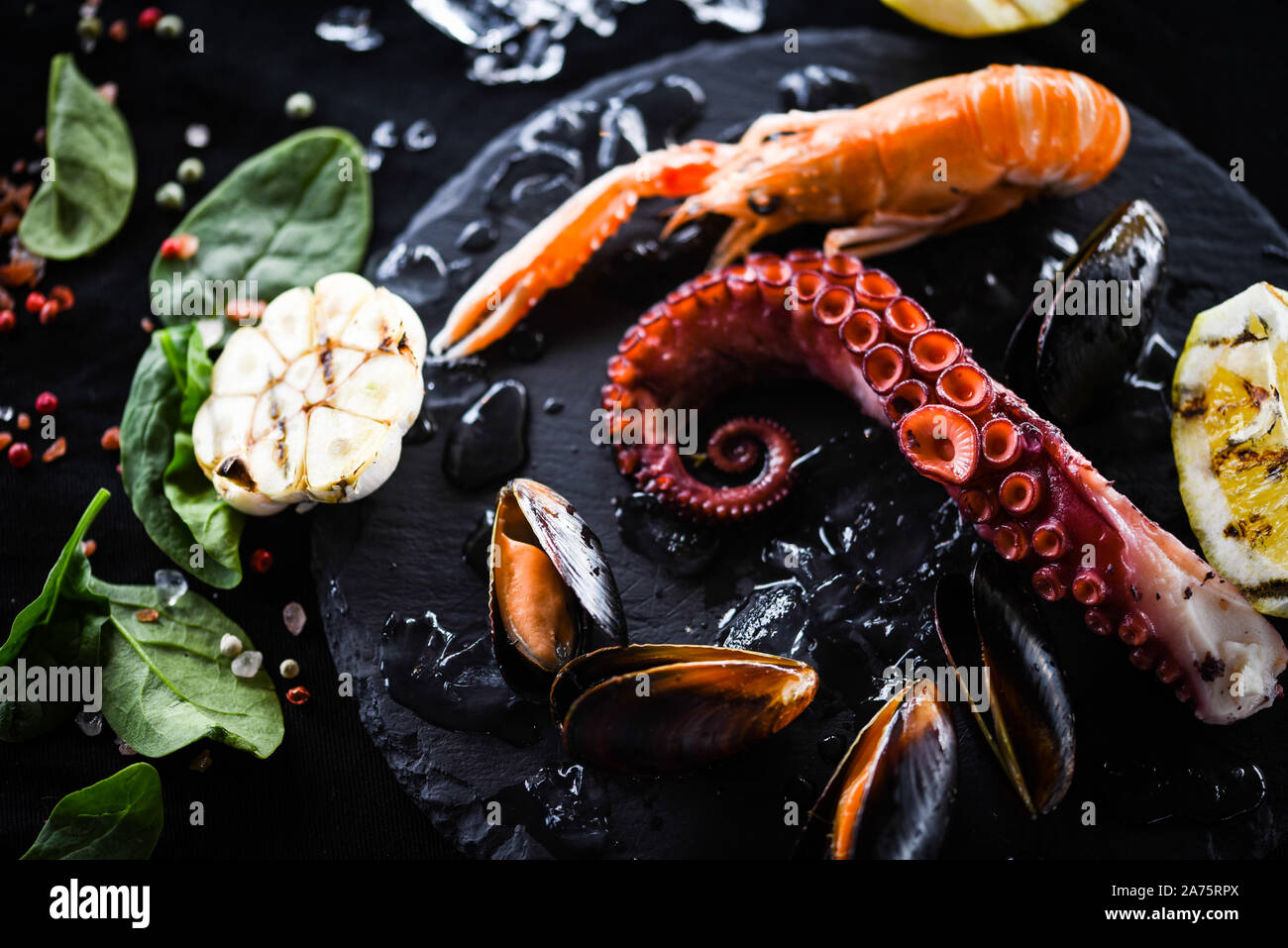 fruits de mer frais avec citron grillé et ail - poulpe, crevettes, calmars, coquillages Banque D'Images