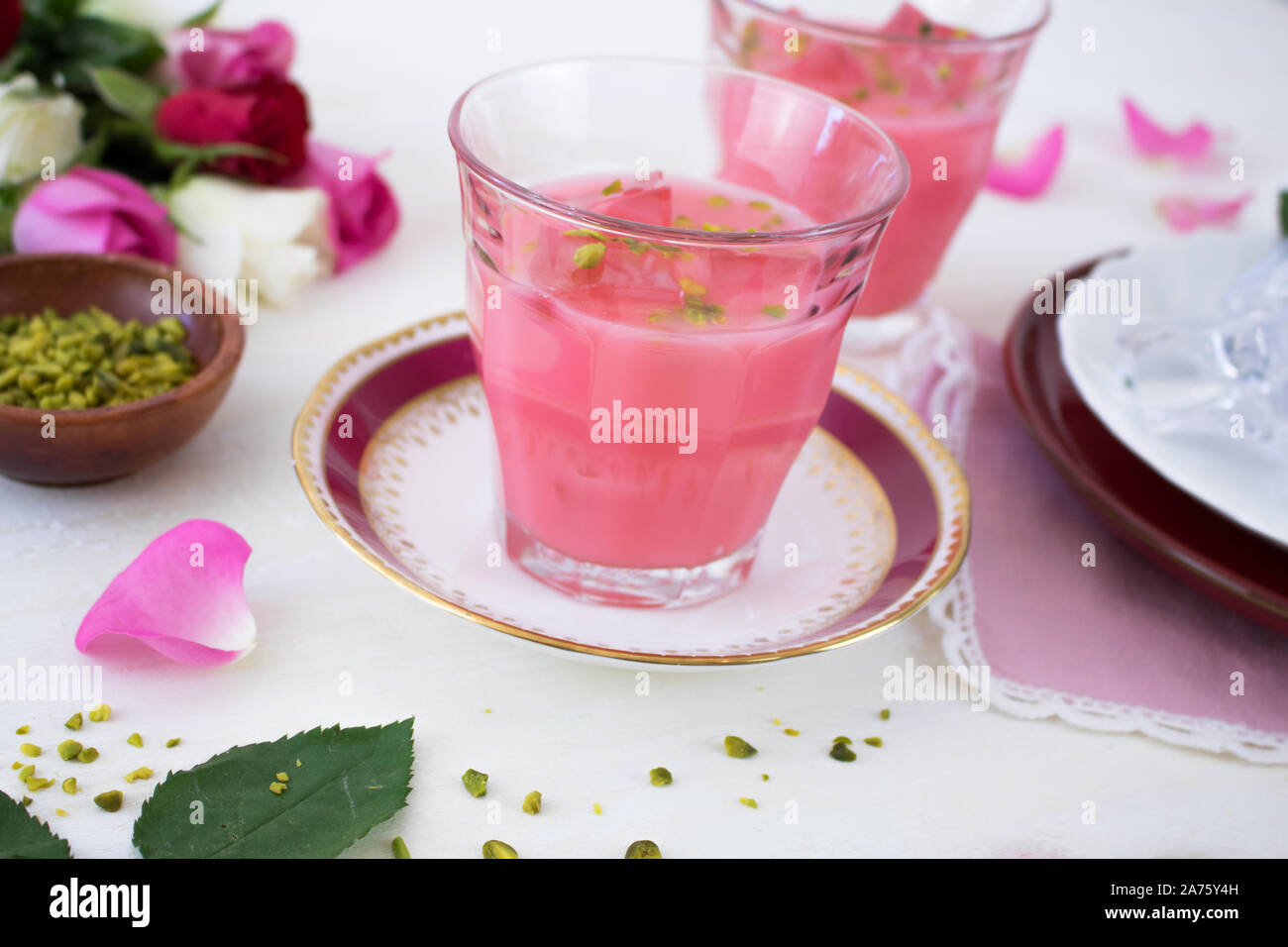 La photographie alimentaire de lait rose indien avec des pétales de rose, de pistaches et de décoration de la Chine. Banque D'Images