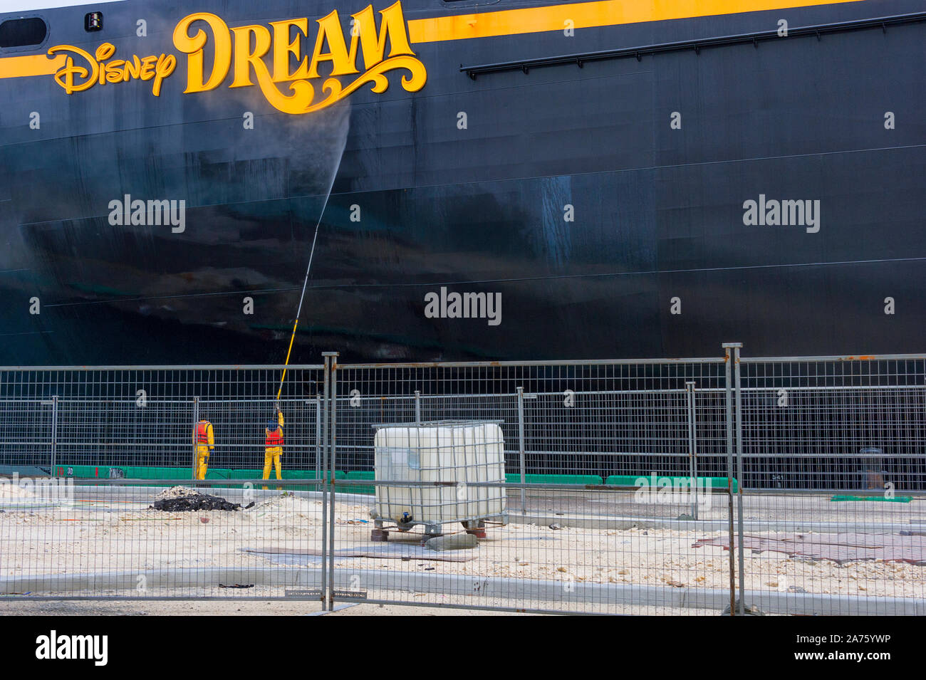 Nassau, Bahamas - septembre 21,2019 : deux hommes vêtus de jaune avec gilet de sécurité orange laver sous pression Disney Dream Cruise Ship amarrée au Prince Ge Banque D'Images
