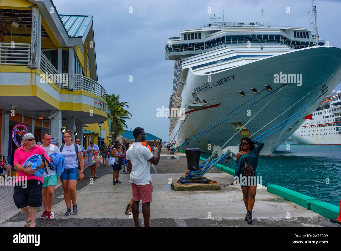 Nassau, Bahamas - septembre 21,2019 : Une jeune femme pose en face d'un navire de croisière que les autres tourtist marche par à Prince George Warf sur New Providence est Banque D'Images