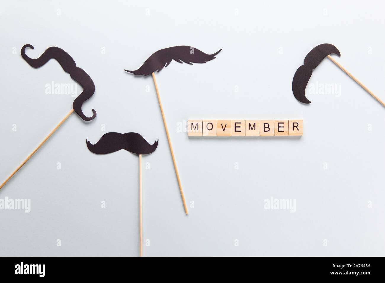 Moscou, Russie - 07 octobre 2019 : Inscription, Movember accessoires dans forme de moustaches noires sur des bâtons sur fond gris. Concept de la santé des hommes, p Banque D'Images