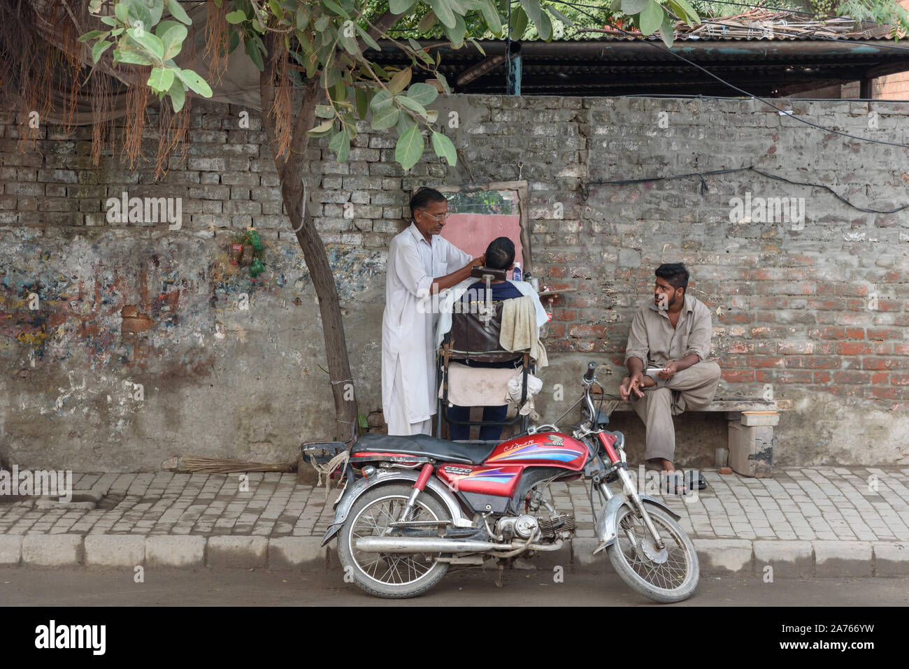 LAHORE, PAKISTAN- le 24 SEP 2019 : coiffure pour hommes travaillant à un blocage des routes à Lahore, Pakistan. Banque D'Images