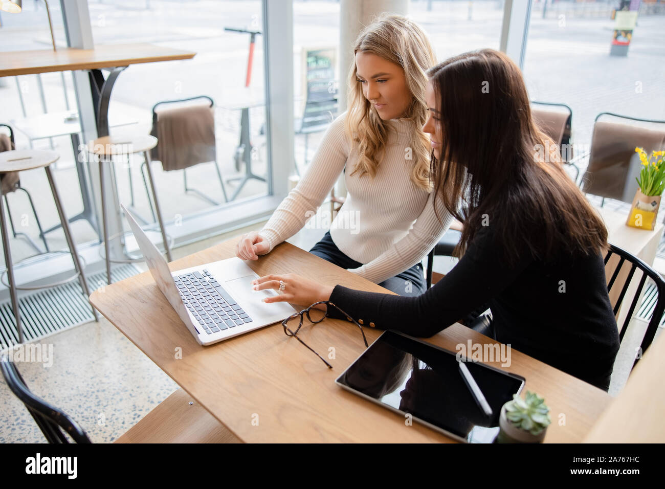 Les amis Discuter Projet scolaire sur ordinateur portable au café Banque D'Images