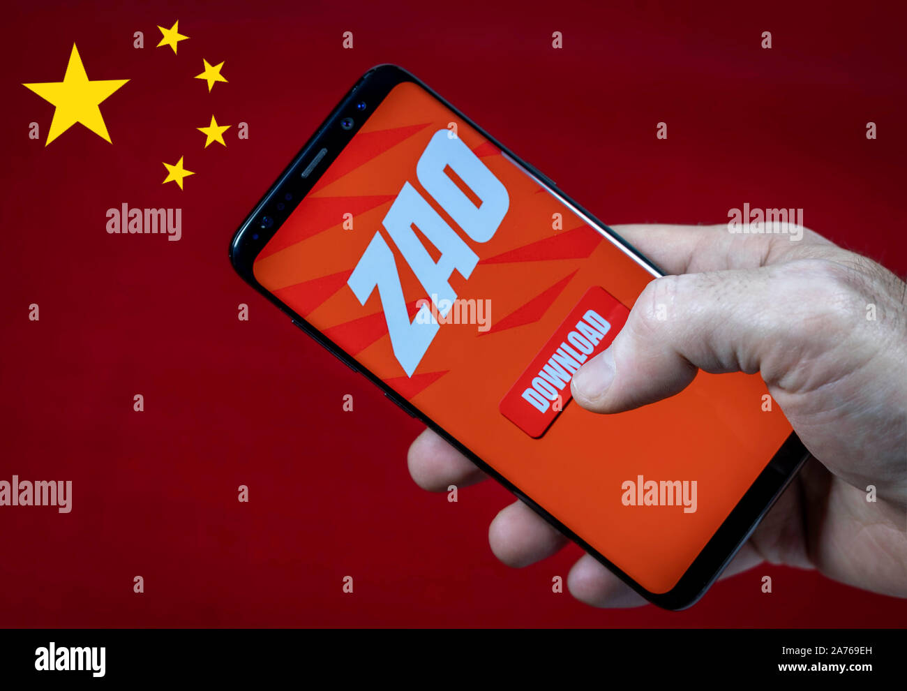 Homme hand holding smartfone avec ZAO app logo et bouton de téléchargement contre la Chine drapeau. Banque D'Images