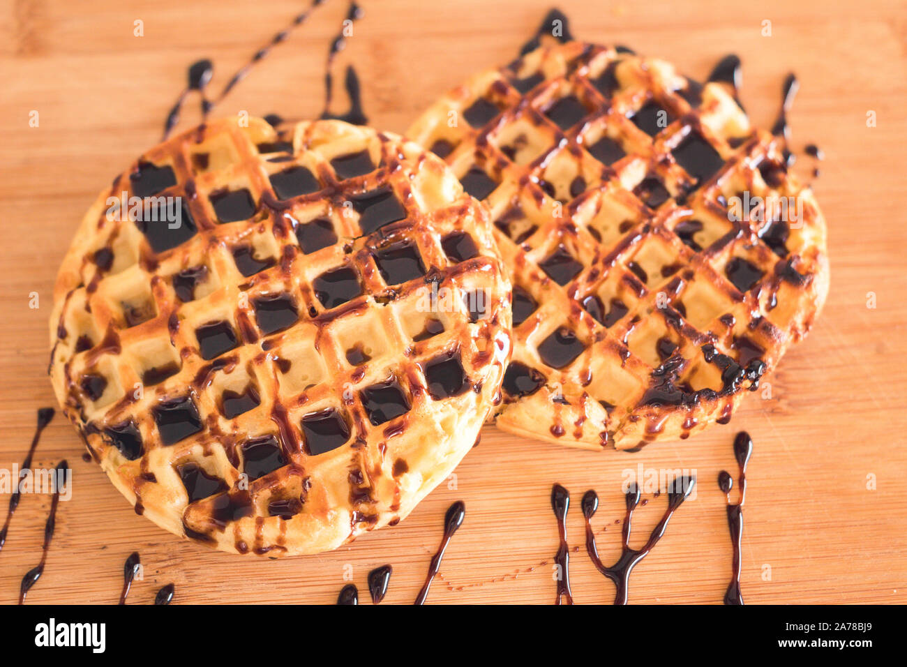 Gaufre avec du sirop de chocolat sur la table en bois Banque D'Images