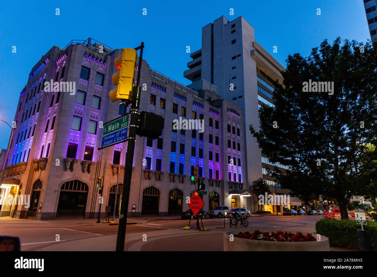 Tulsa, Oklahoma, USA. 13 mai, 2019. Les bâtiments illuminés la nuit avec à côté d'une rue. Travaux routiers de l'avant panneau de circulation. Banque D'Images