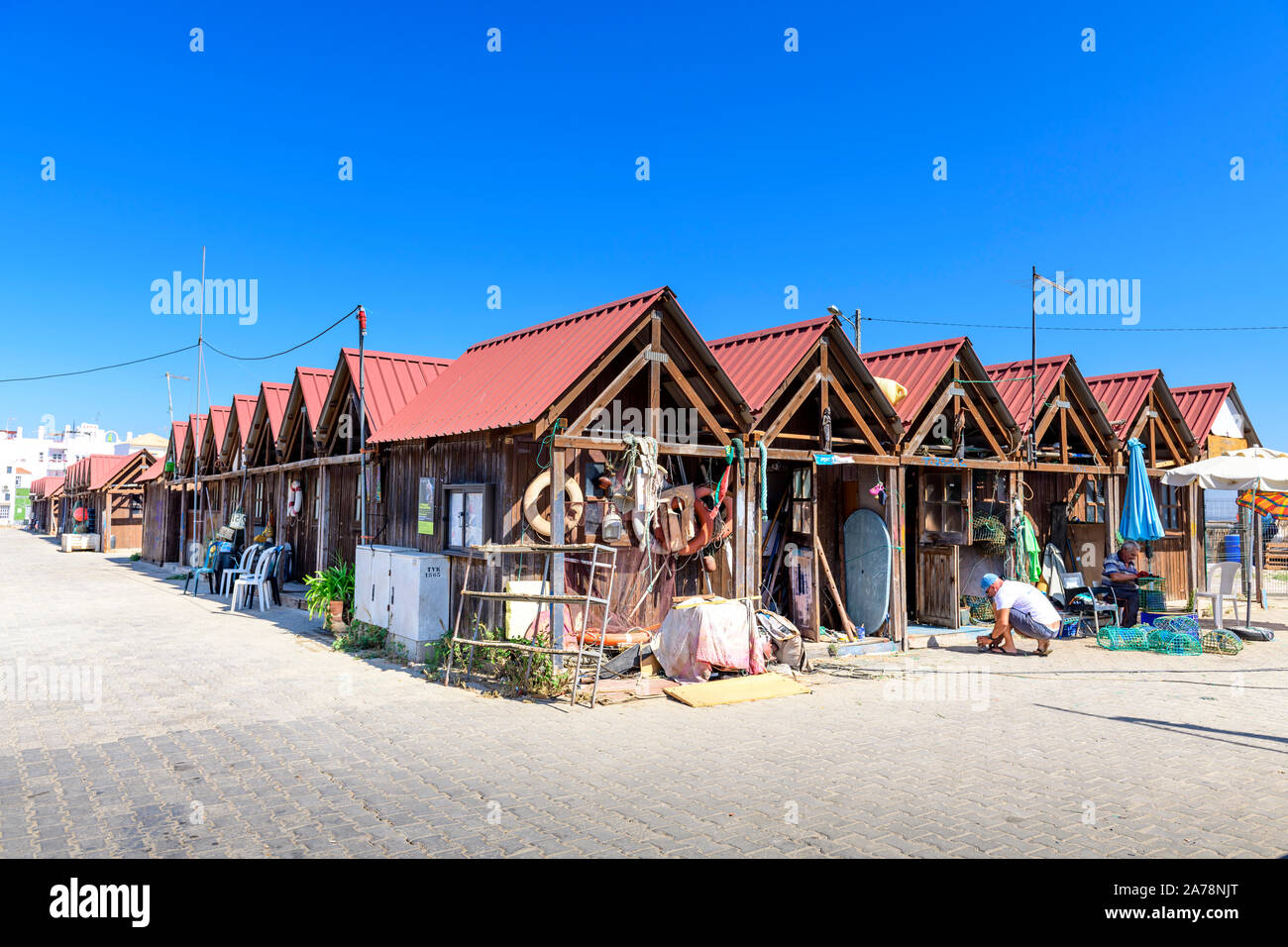 Santa Luzia rangées de pêcheurs de cabanes de pêcheurs et de matériel de pêche sur le front de mer. Santa Luzia, Algarve, Portugal. . Banque D'Images