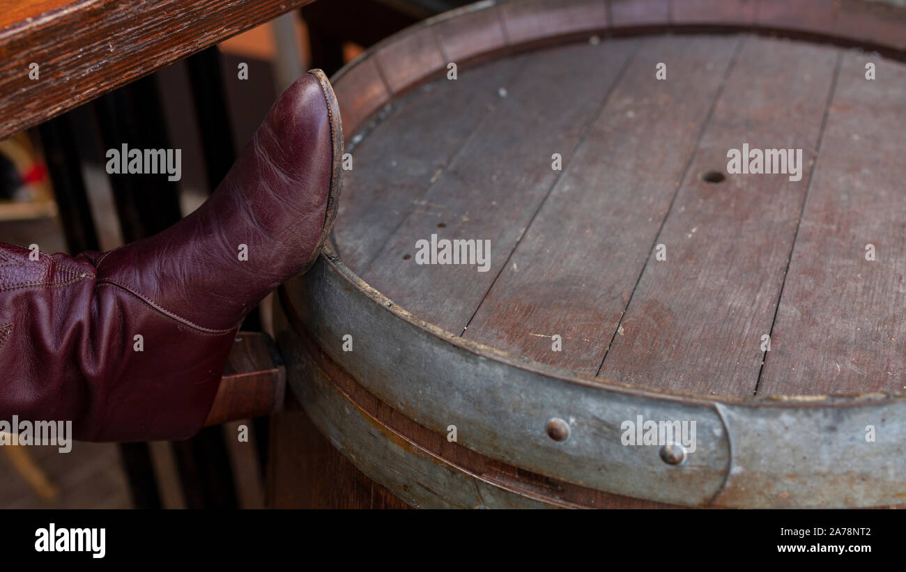 Des bottes pour dames rouge repose sur le vieux vin baril Banque D'Images