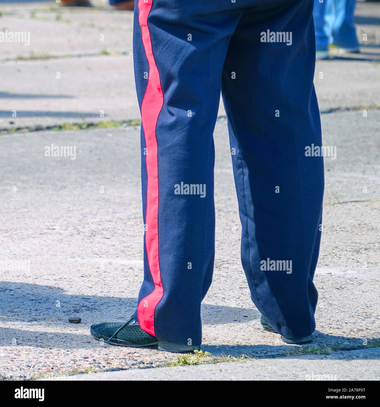 Pantalon bleu avec une bande rouge sur le militaire. Les bandes