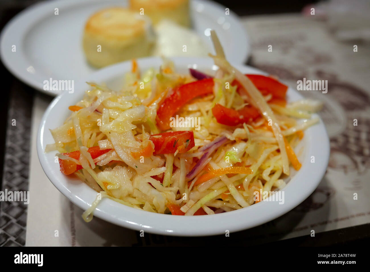 Salade de légumes frais sain avec du chou qui mélange avec poivron rouge dans une assiette blanche. Concept de l'alimentation végétarienne saine. Focus sélectif. Cl Banque D'Images