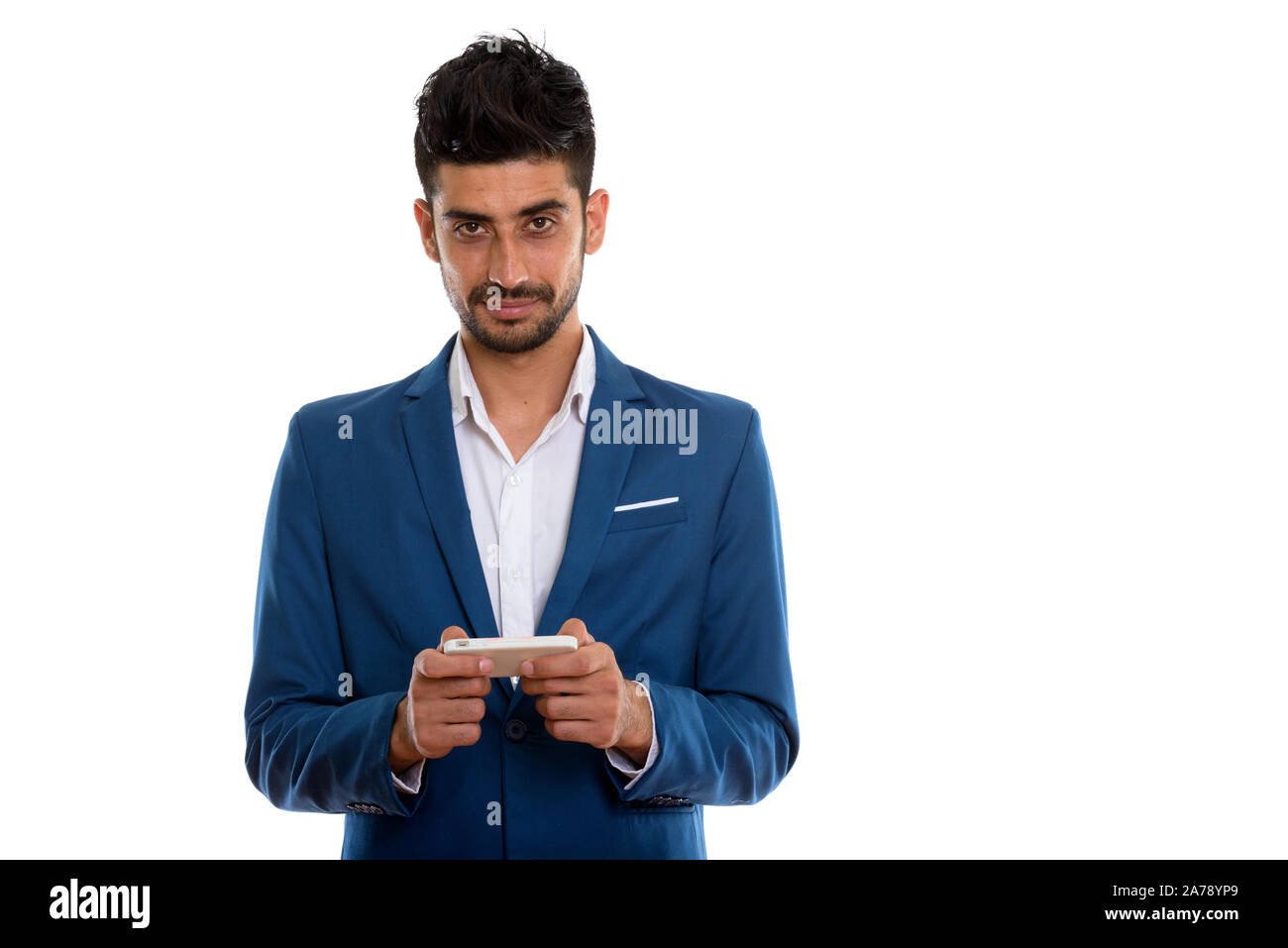 Beau jeune homme barbu en Perse suit en utilisant phone Banque D'Images