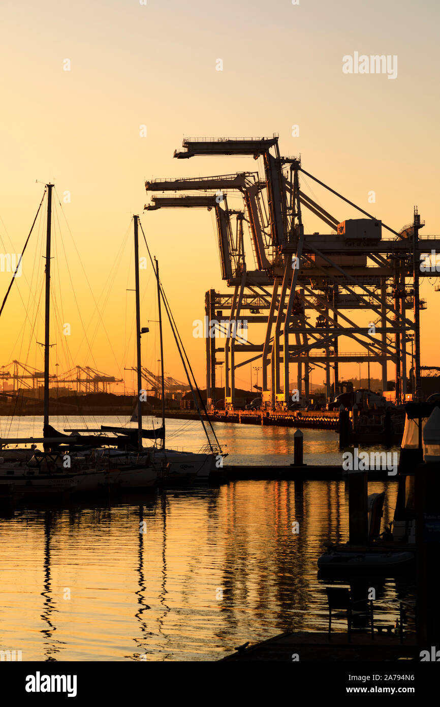 Coucher de soleil sur les gratte-ciel de San Francisco et les grues de levage lourd Oakland Port, Oakland, Californie Banque D'Images