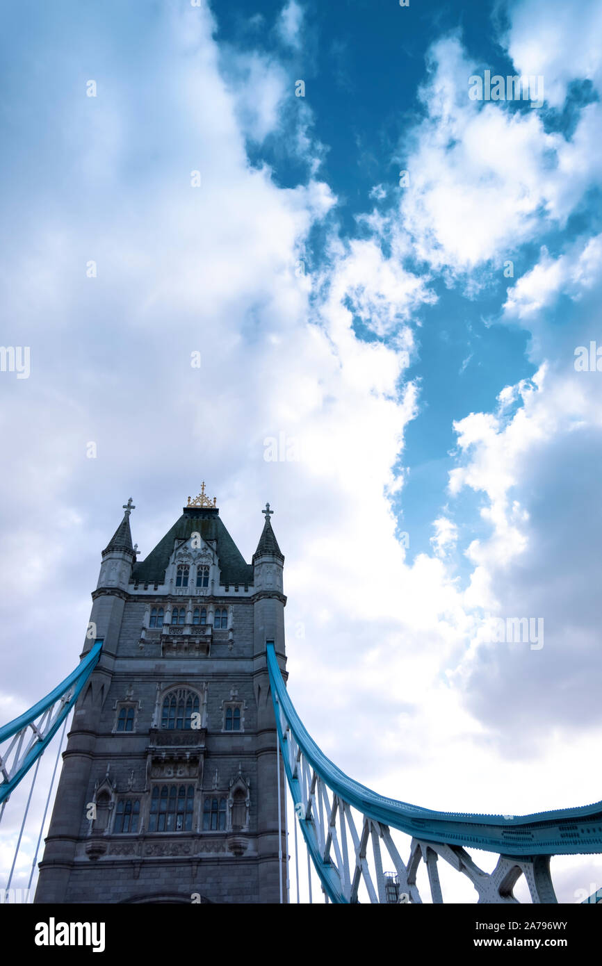 Vue rapprochée de la majestueuse Tower Bridge, un établissement emblématique de Londres, contre un ciel bleu avec des nuages blancs gonflées. Banque D'Images