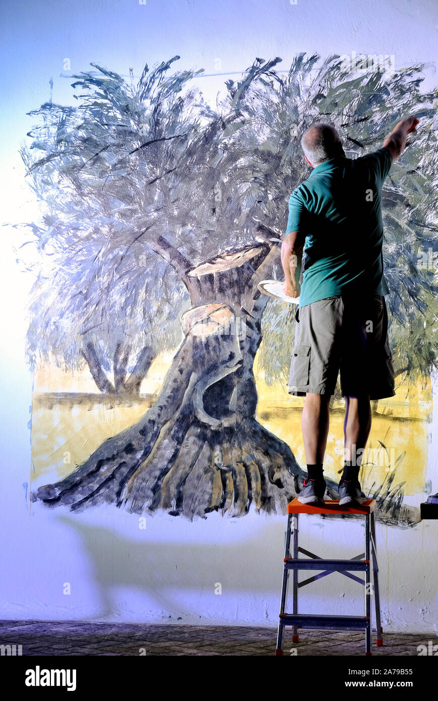 Fasutino Castillo Plaza peindre une fresque d'un olivier pour illustrer un poème de Manuel Molina Gonzalez. Carcabuey, Cordoue, Andalousie. L'Espagne. Banque D'Images