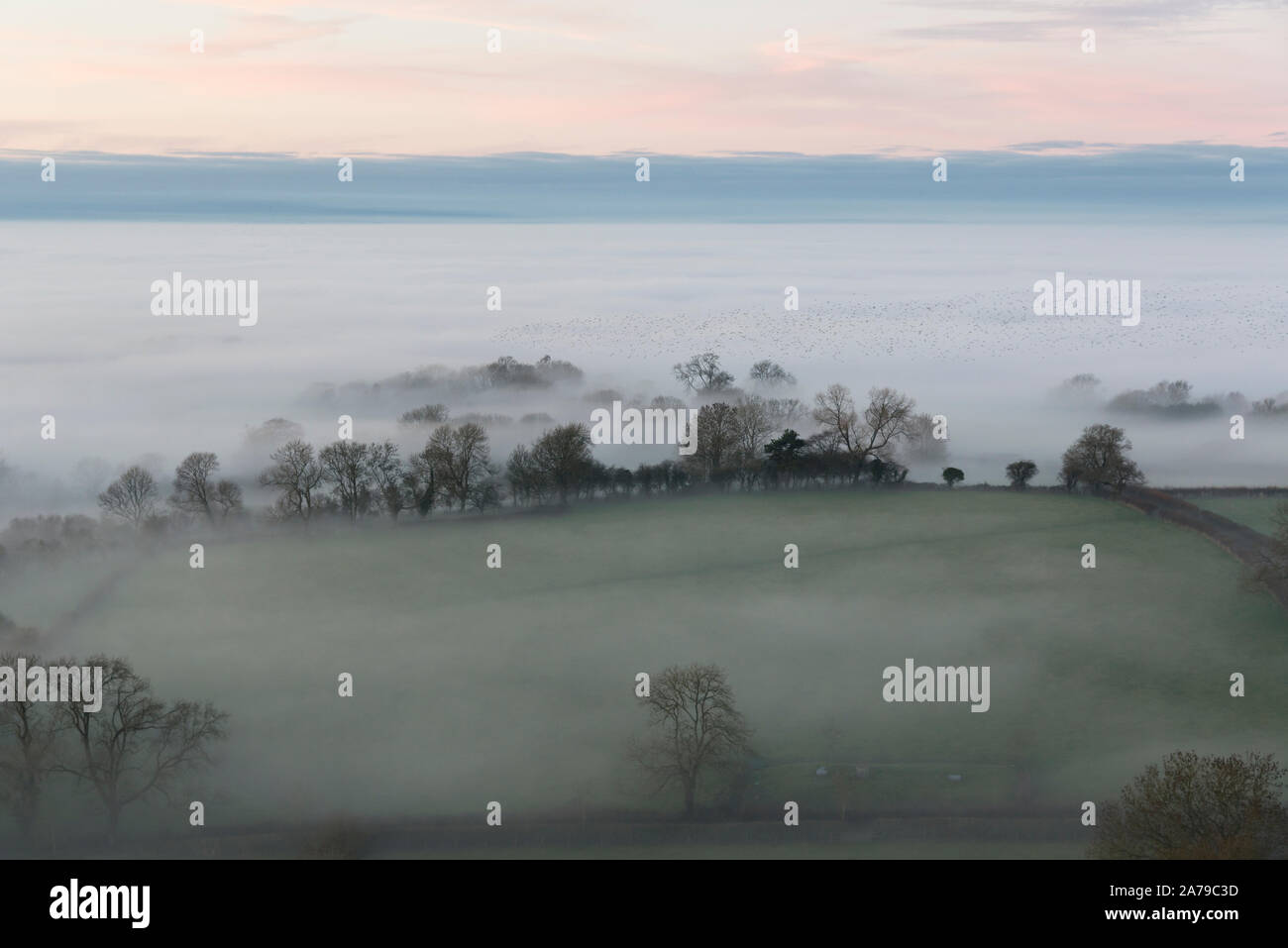 Météo France, Glastonbury, Somerset, Royaume-Uni, 27 décembre 2018. Le brouillard et le coucher du soleil le Tor de Glastonbury. Banque D'Images