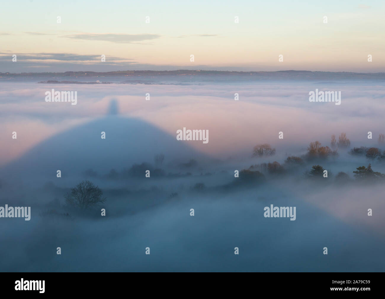 Météo France, Glastonbury, Somerset, Royaume-Uni, 27 décembre 2018. Le brouillard et le coucher du soleil le Tor de Glastonbury. Banque D'Images