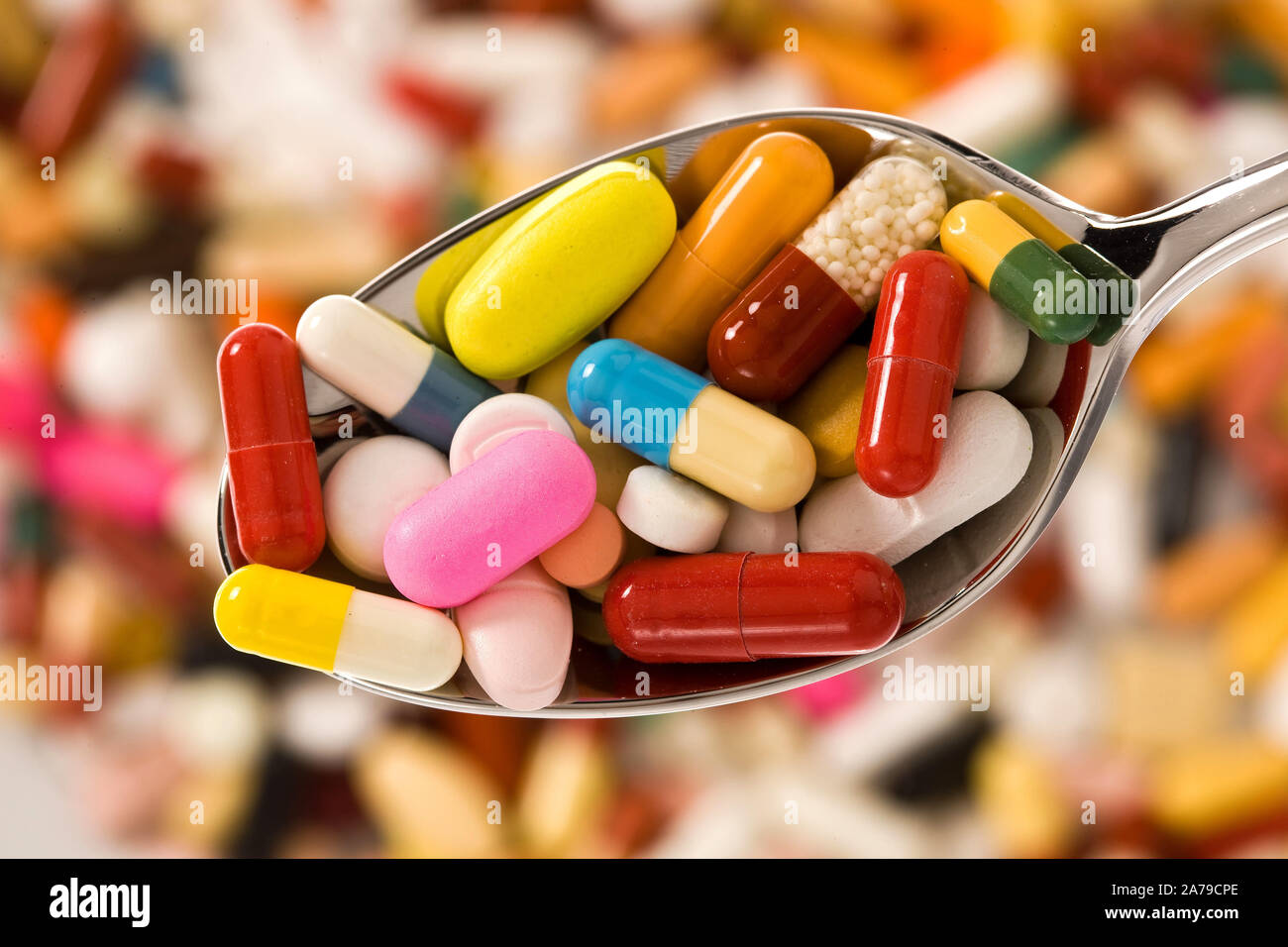 Liegen auf einem Löffel viele bunte Tabletten, Tablettensucht Medikamentensucht Abhängigkeit,,, Banque D'Images