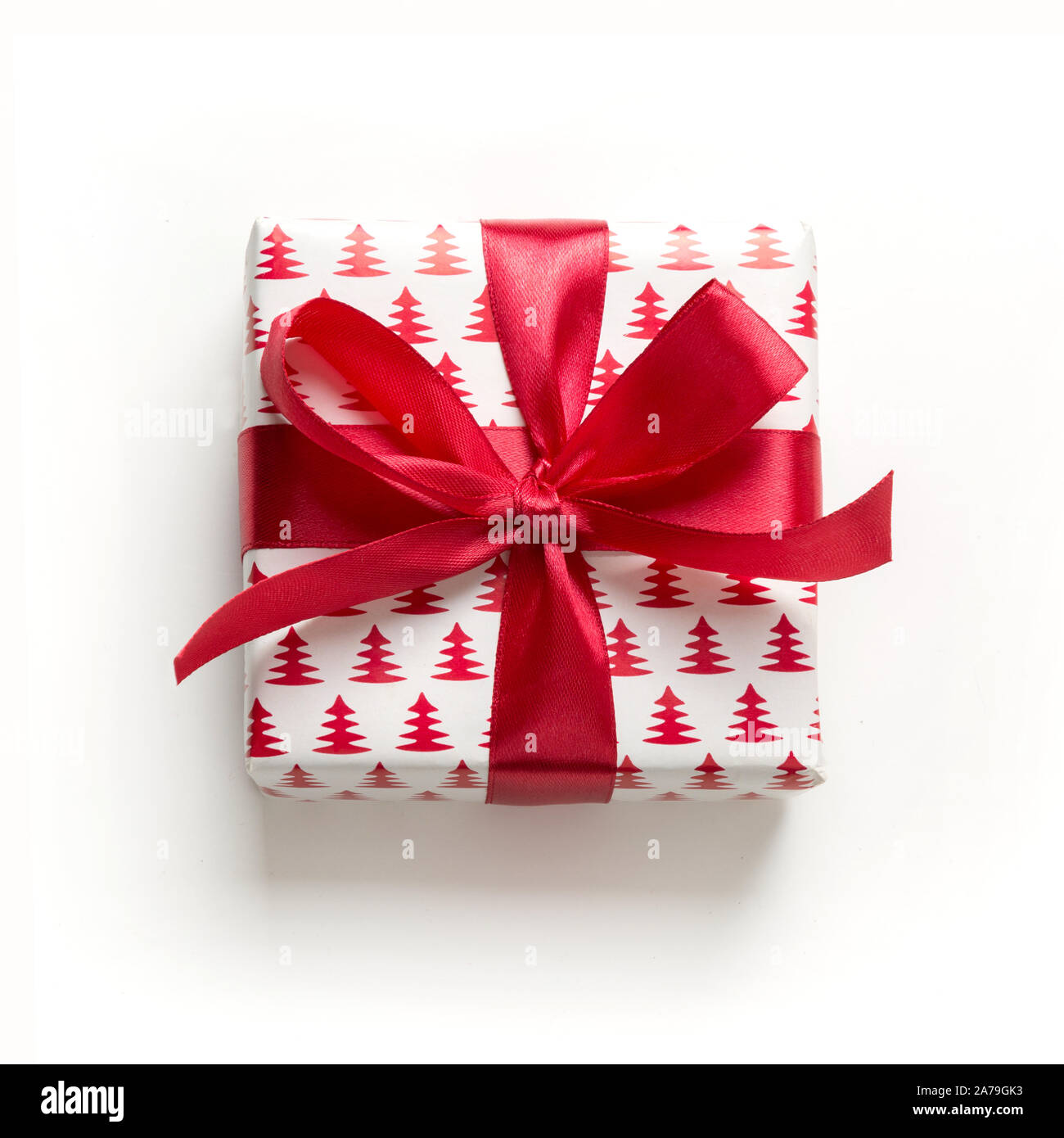 Cadeau de Noël avec arc rouge sur fond blanc. Modèle de Noël. Bonne Année. Mise à plat de style. Banque D'Images