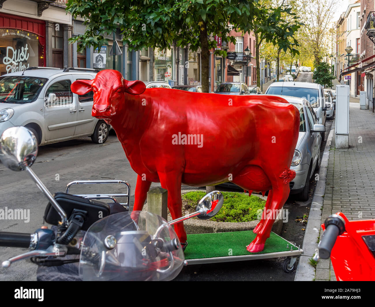 Life-size Red cow sculpture sur coin de rue de Saint Gilles, Bruxelles, Belgique. Banque D'Images