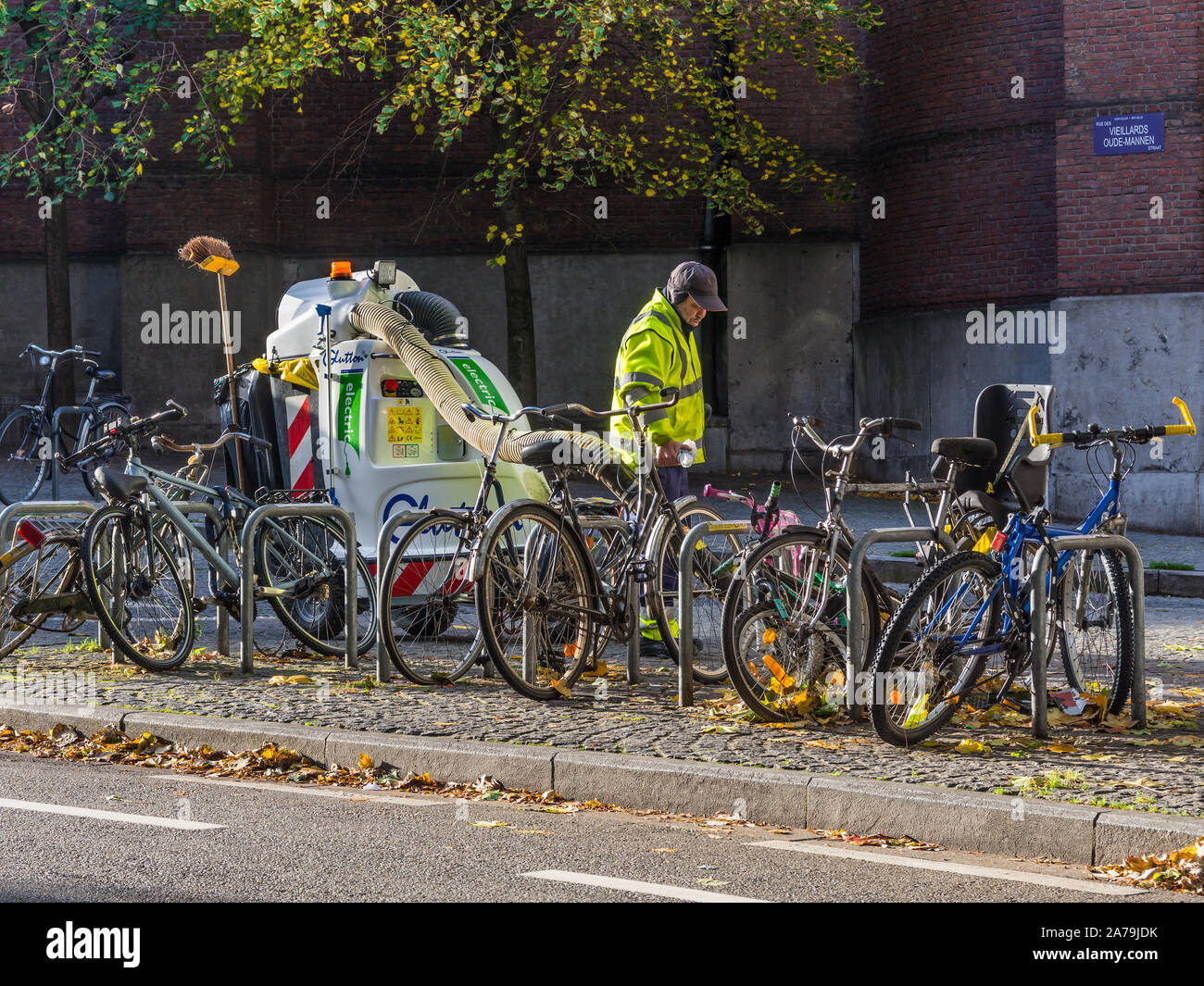 Travailleur du Conseil de l'automne les feuilles de collecte avec 'Glouton' machine électrique - Bruxelles, Belgique. Banque D'Images