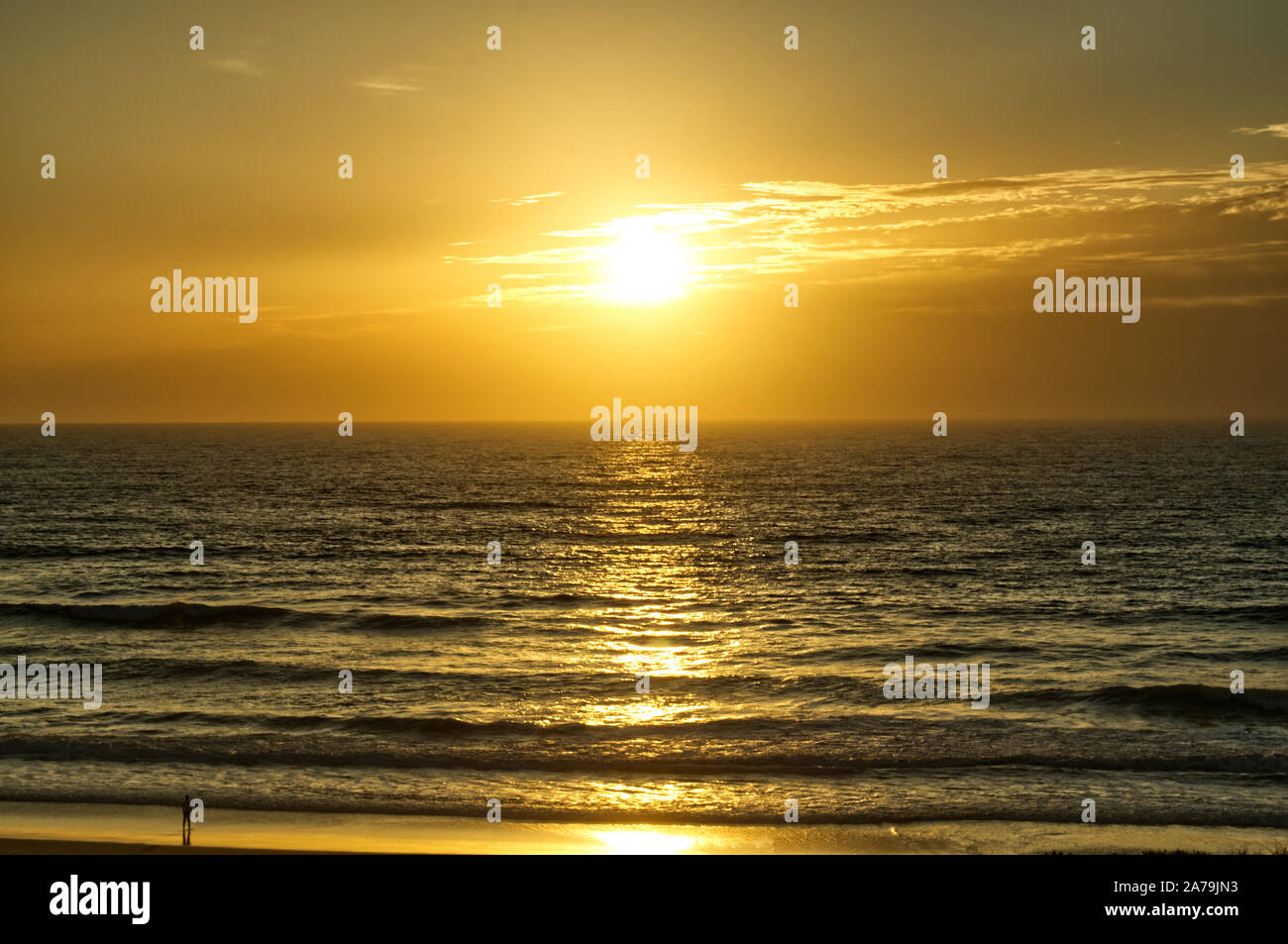 Une personne solitaire observe le coucher du soleil de la plage tout en vagues tour doucement sur le rivage à Argelès-sur-Mer, côte Atlantique, France Banque D'Images