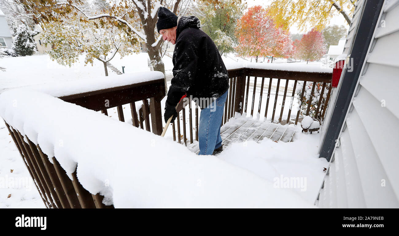 Davenport, Iowa, États-Unis. 31 octobre, 2019. Robert Miller efface son porche de sa maison sur la rue Rushholme à Davenport, Iowa des trois pouces de neige qui est tombée pendant la nuit Jeudi, 31 octobre 2019. Crédit : Kevin E. Schmidt/Quad-City Times/ZUMA/Alamy Fil Live News Banque D'Images