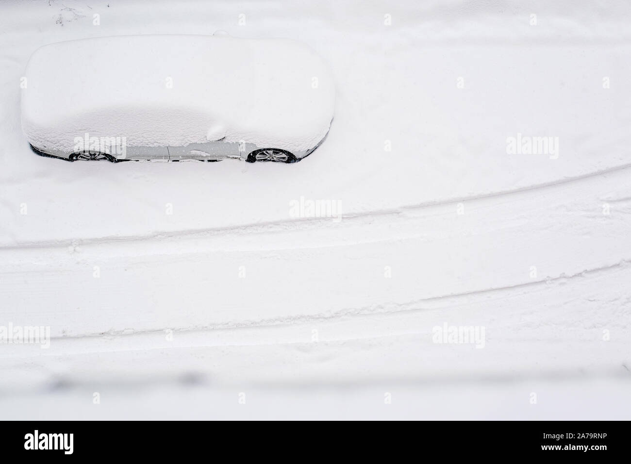 Vue de dessus sur silver car enterré dans la neige sur la route après blizzard. Beaucoup de neige dans la ville. Après une tempête de neige. Copier l'espace. Tempête de neige. L'espace pour le texte. Banque D'Images