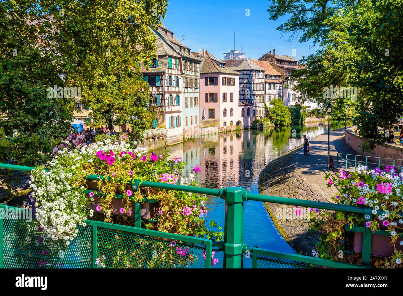 Fleurs en pot décorer un pont sur l'Ill canal dans le quartier de la Petite France à Strasbourg, France, bordée de maisons à colombages. Banque D'Images