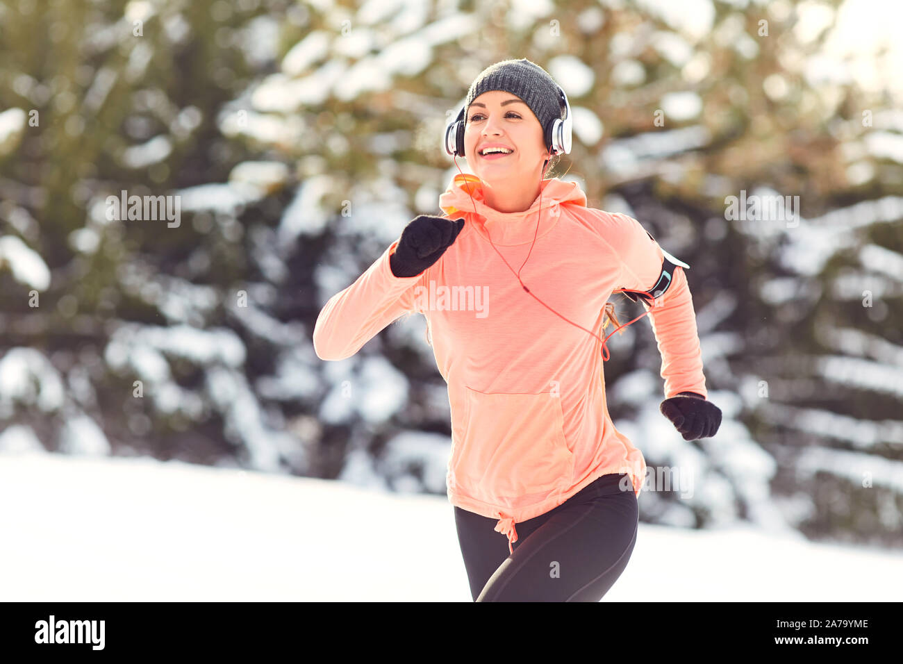 Woman jogging dans la neige sur la nature en hiver Banque D'Images